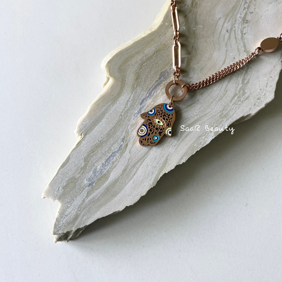 Metal chain necklace with a pendant in the shape of a A PALM OF EVIL EYE. Adjustable length with a trigger clasp. Accessory Style: Pendant necklace Description: PREMIUM PROTECTING BLUE EVIL EYE NECKLACE Country of production: India Common generic name: Necklace Net Quantity: 1 N Composition Metal 80%, Polymethyl methacrylate 10%, Steel 10%