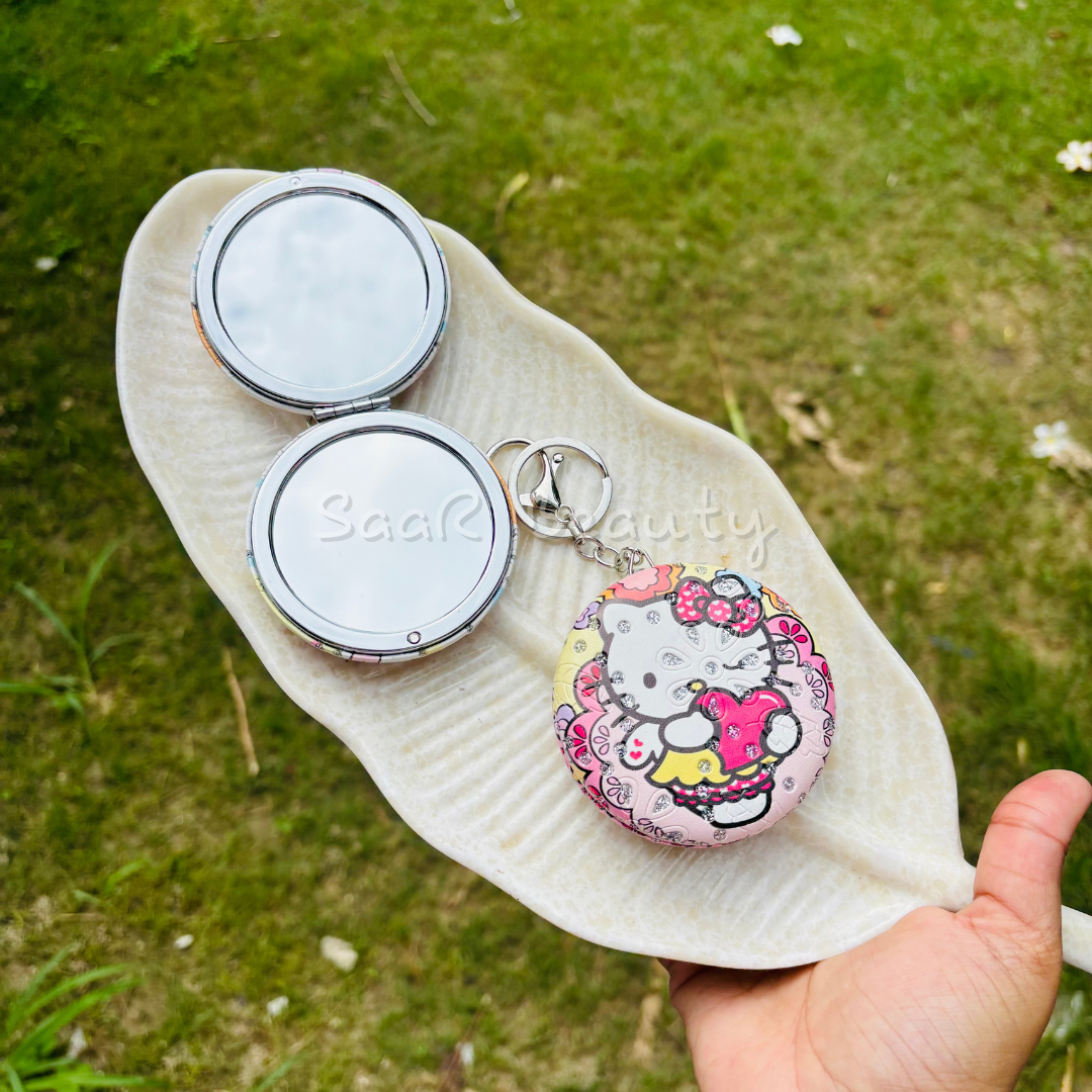 Compact mirror with a Hello Kitty design on a leaf against a grassy Premium Saar Beauty keychain mirrors with Hello Kitty and Evil Eye designs – compact, portable, and durable pocket mirrors for women and girlsbackground