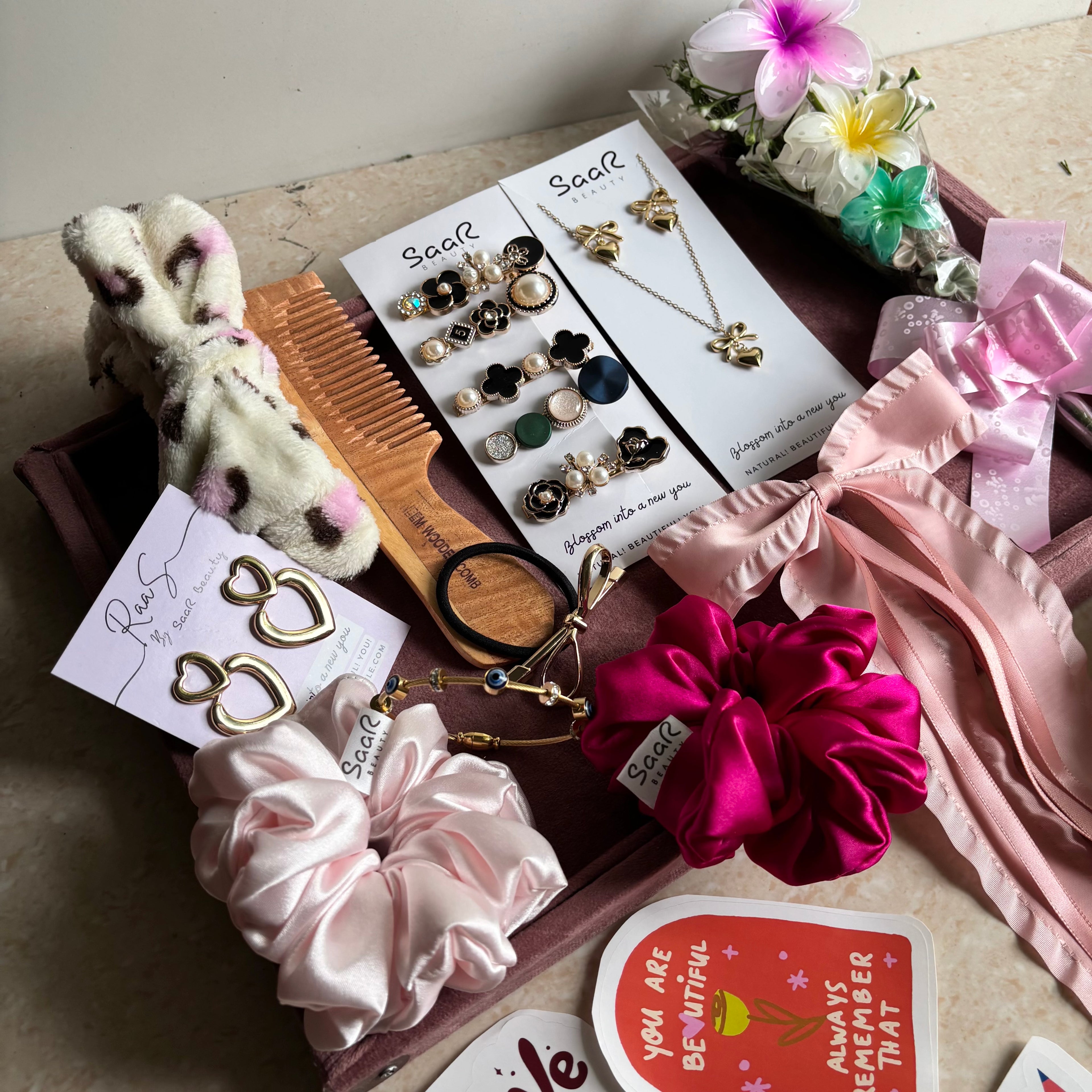 Premium Rakshabandhan gift hamper from Saar Beauty featuring satin scrunchies, anti-tarnish jewelry, flower hair clips, Korean clip set & wooden comb.