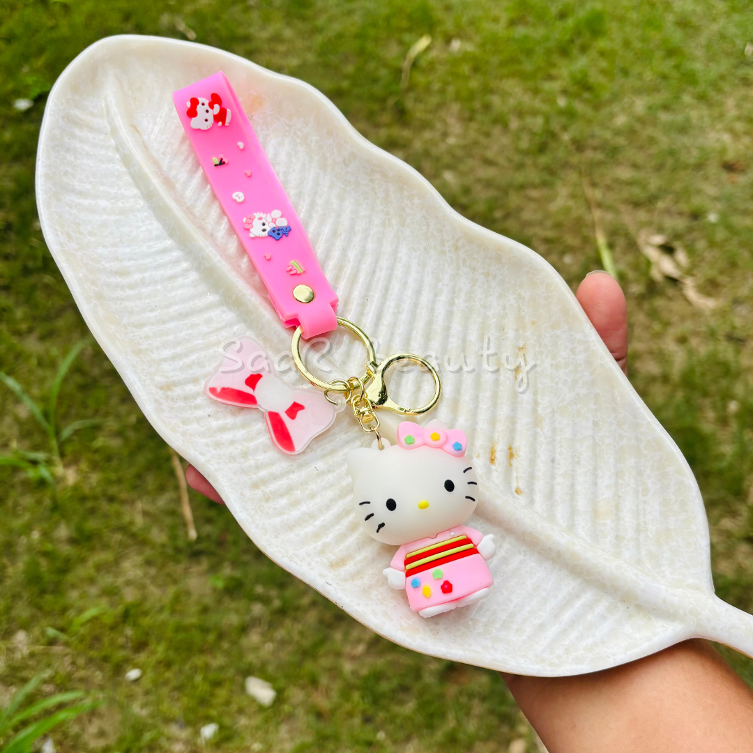 White sandal with a Hello Kitty charm on a grassy background Premium cute cartoon keychains by Saar Beauty featuring Hello Kitty, Shinchan, Kuromi, Starbucks drink, boba tea, and pink bow designs – durable, trendy, and stylish for women, kids, and girl