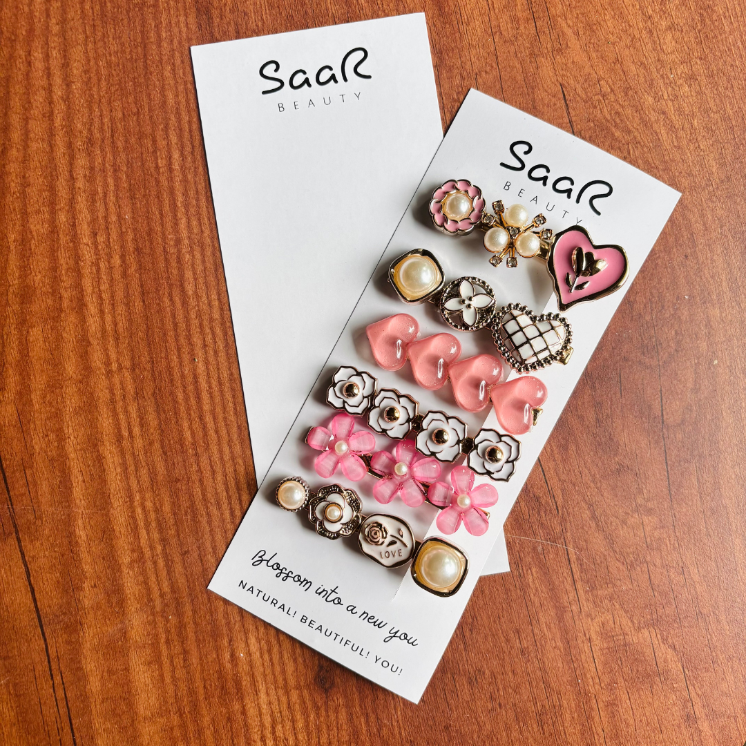 Premium Korean hair clip set by Saar Beauty with pearl, heart, and floral designs – trendy and stylish hair accessories for women, kids, and girls. Set of decorative hair clips on a Saar Beauty branded card on a wooden surface