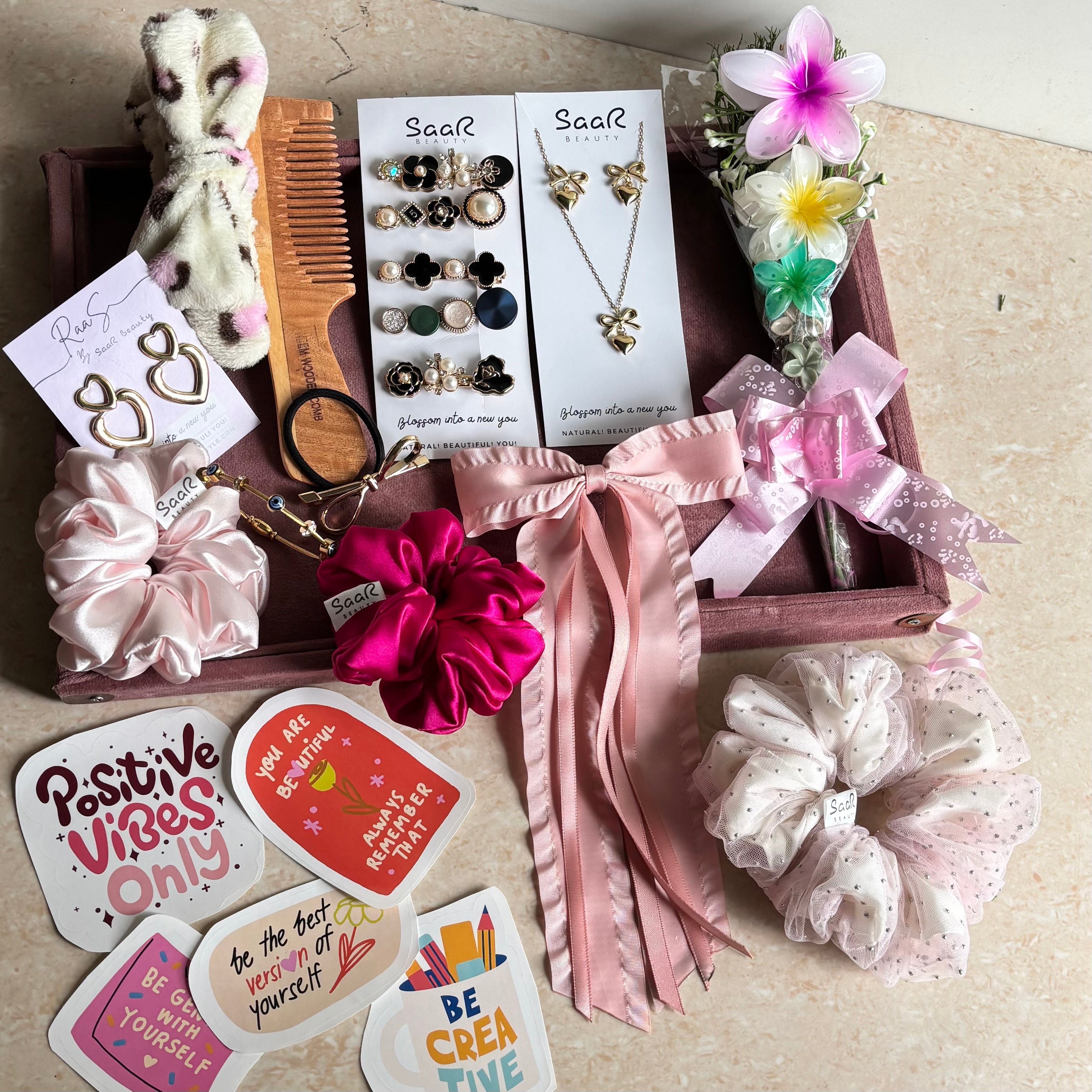 Premium Rakshabandhan gift hamper from Saar Beauty featuring satin scrunchies, anti-tarnish jewelry, flower hair clips, Korean clip set & wooden comb.