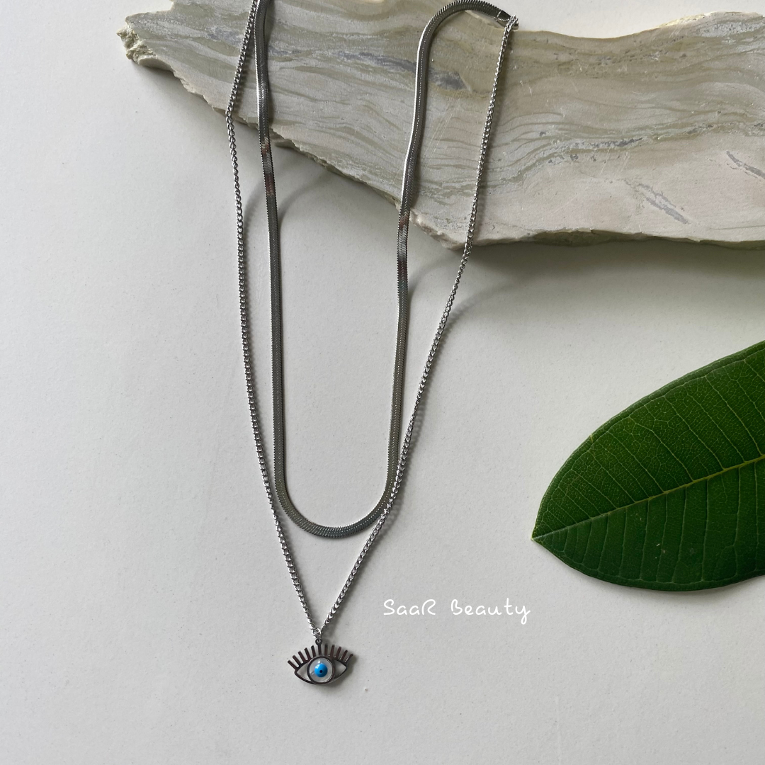 Metal chain necklace with a pendant in the shape of a EVIL EYE. Adjustable length with a trigger clasp. Accessory Style: Pendant necklace Description: ANTI TARNISH SILVER SNAKY EVIL EYE PENDANT NECKLACE NECKPIECE Country of production: India Common generic name: Necklace Net Quantity: 1 N Composition Metal 80%, Polymethyl methacrylate 10%, Steel 10%