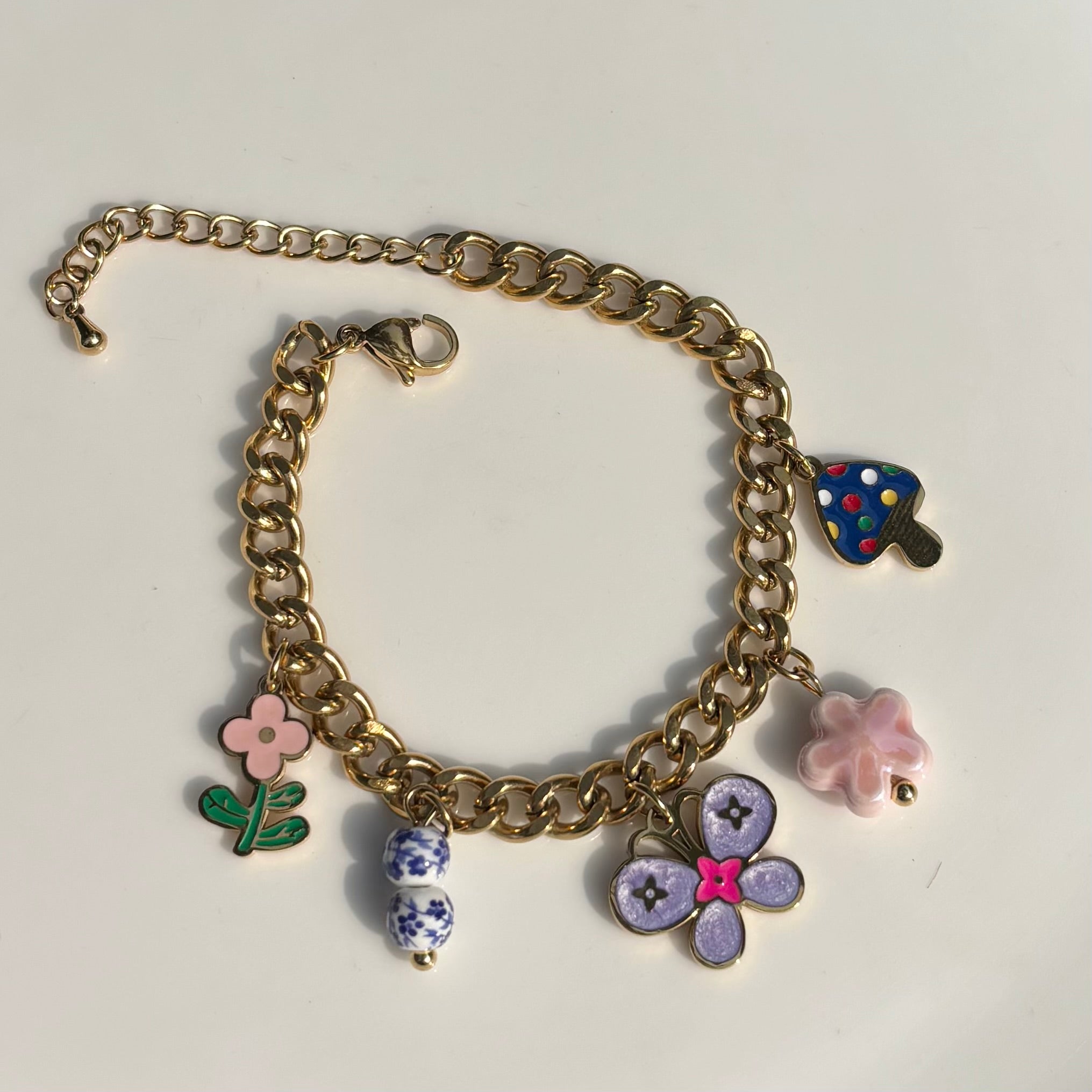 Gold chain bracelet with colorful charms on a white background Saar Beauty floral charm gold bracelet for women – waterproof fashion jewellery