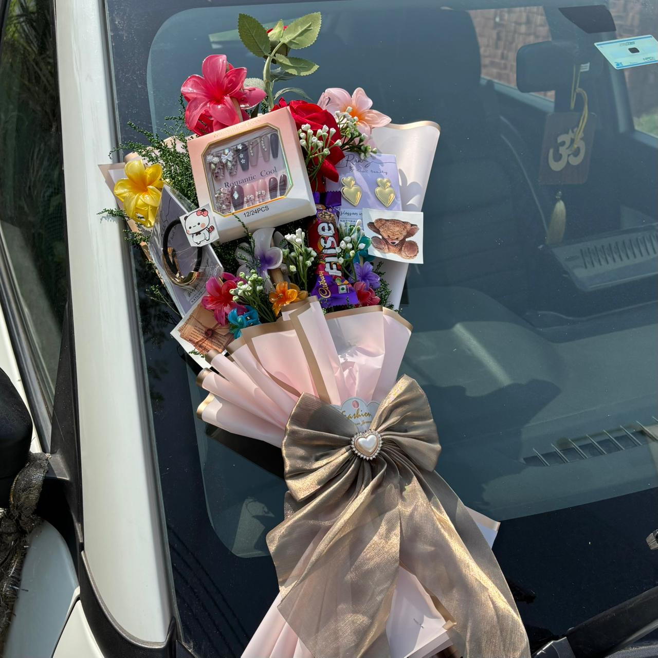 Bouquet of flowers with a bow attached to a car window Pinterest-inspired Saar Beauty Forever Gift Bouquet with hair claws, nail box, and jewelry