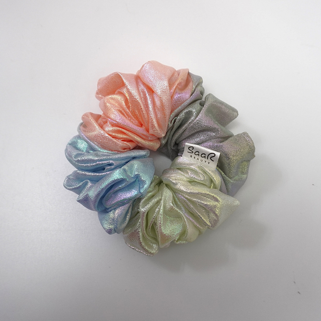 Holographic fluffy scrunchies made from different colored fabrics, each with a color changing effect, creating a unique and eye catching accessory