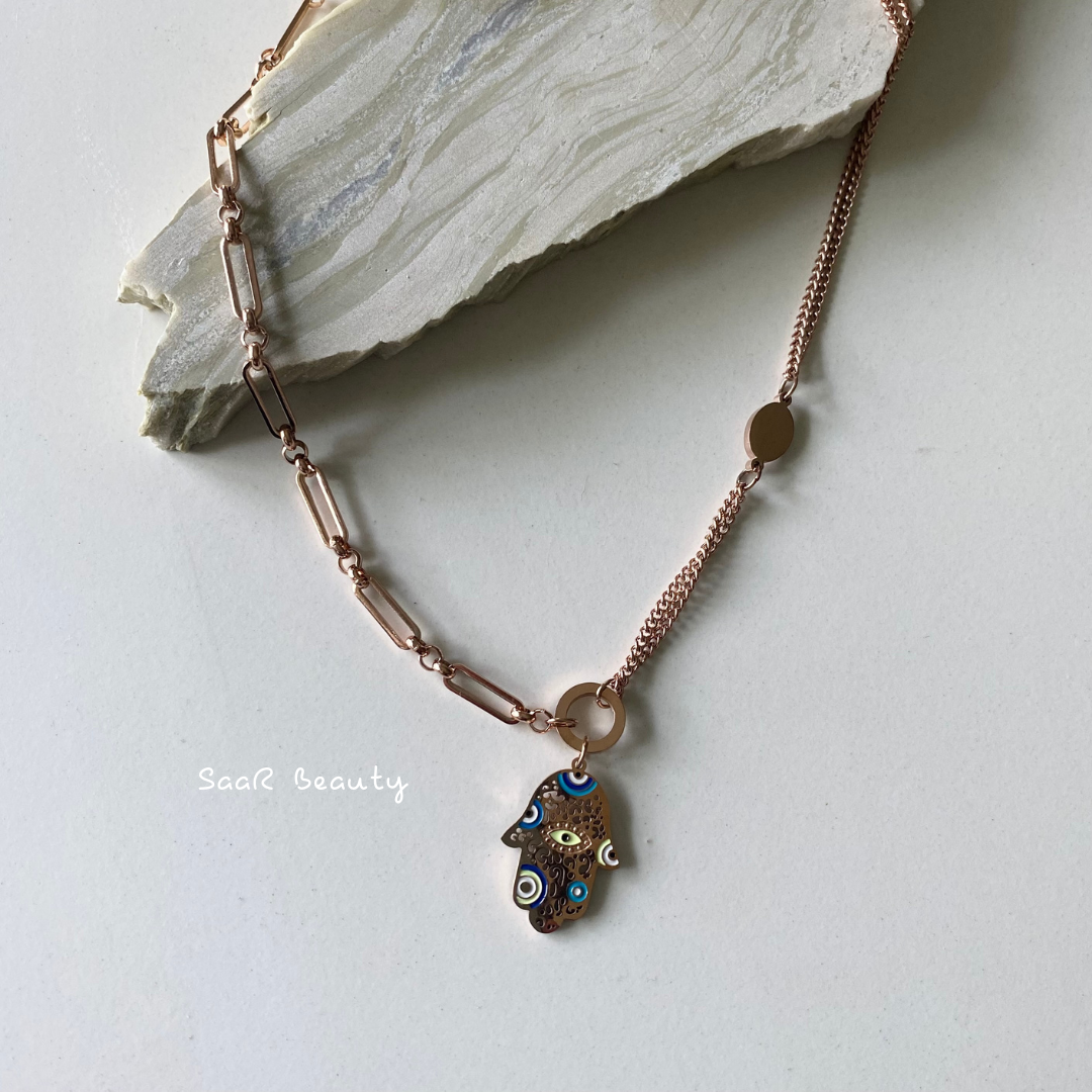 Metal chain necklace with a pendant in the shape of a A PALM OF EVIL EYE.&amp;nbsp;Adjustable length with a trigger clasp.  Accessory Style:&amp;nbsp;Pendant necklace Description: PREMIUM PROTECTING BLUE EVIL EYE NECKLACE Country of production:&amp;nbsp;India Common generic name:&amp;nbsp;Necklace Net Quantity:&amp;nbsp;1 N     Composition  Metal 80%, Polymethyl methacrylate 10%, Steel 10%