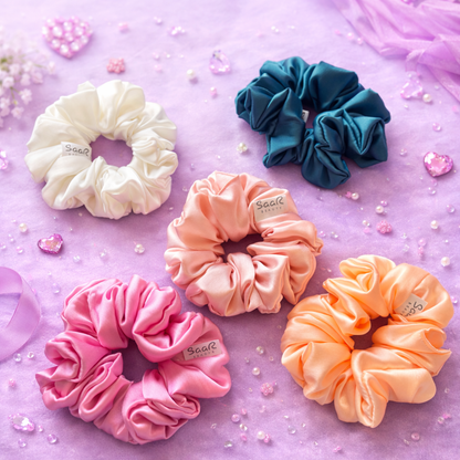 Set of five colorful scrunchies on a pink background Saar Beauty Japanese satin scrunchies set of 5 soft silk hair ties