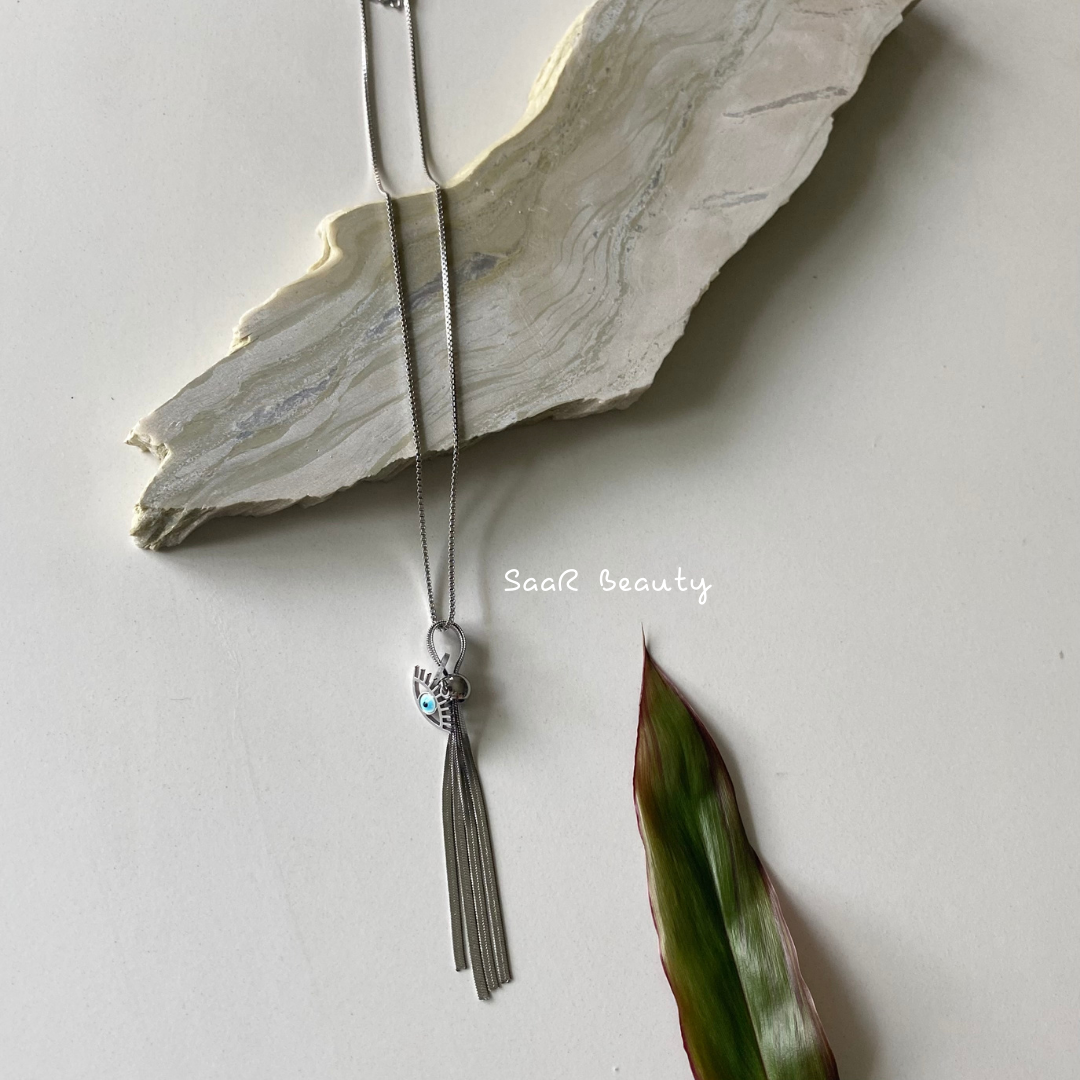 Metal chain necklace with a pendant in the shape of a EVIL EYE AND TESSEL&amp;nbsp; .&amp;nbsp;Adjustable length with a trigger clasp.  Accessory Style:&amp;nbsp;Pendant necklace Description: PROTECTING EVIL EYE NECKLACE WITH LASHES&amp;nbsp; Country of production:&amp;nbsp;India Common generic name:&amp;nbsp;Necklace Net Quantity:&amp;nbsp;1 N     Composition  Metal 80%, Polymethyl methacrylate 10%, Steel 10%