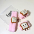Plush toys shaped like cartoon toast with smiling faces on a white  Pink plush skincare headband with bread design and water-absorbing hand wrapsbackground
