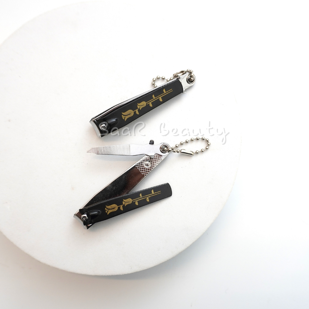 Durable black nail cutter with built-in filer and golden rose design by SaaR Beauty