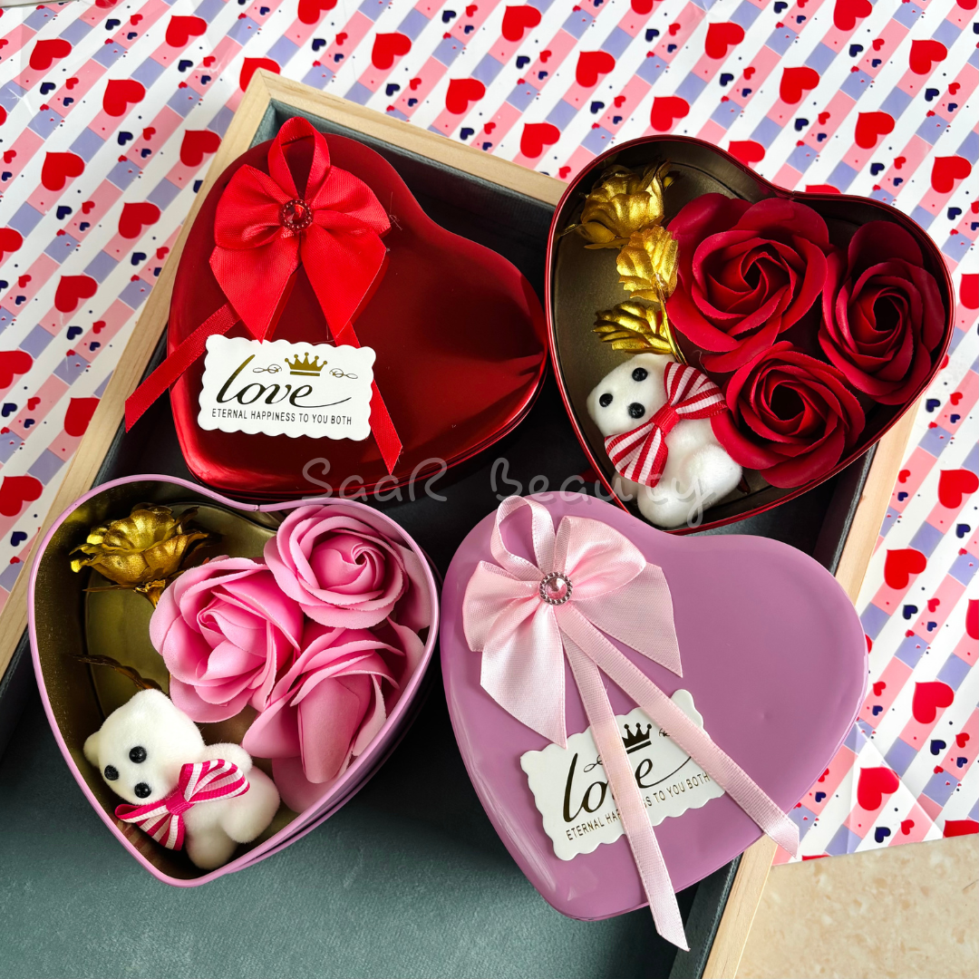 Heart-shaped Valentine’s Day gift box with artificial roses, a small teddy bear, a golden rose, and a decorative ribbon—perfect for romantic occasions.