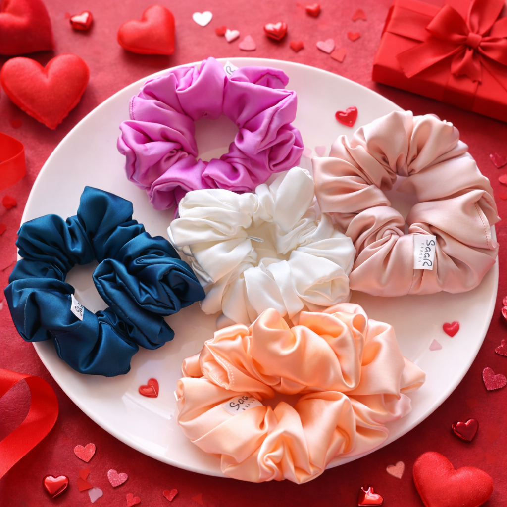 Set of colorful scrunchies on a white plate with a red background and heart decorations. Saar Beauty Japanese satin scrunchies set of 5 soft silk hair ties