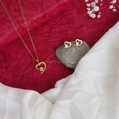 Gold-plated asymmetrical heart necklace with matching earrings displayed on a red and white background.