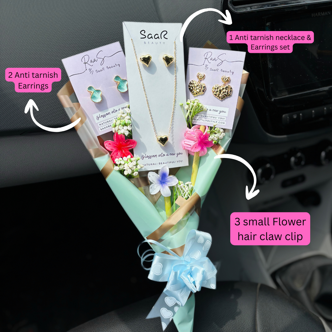 Set of jewelry and accessories including earrings, a necklace, and a hair clip, presented as a bouquet.Premium gift bouquet by Saar Beauty with anti-tarnish heart necklace and earrings, pastel floral wrapping, and small flower claw hair clips. Ideal for thick hair, long hair, and gifting special women and girls.