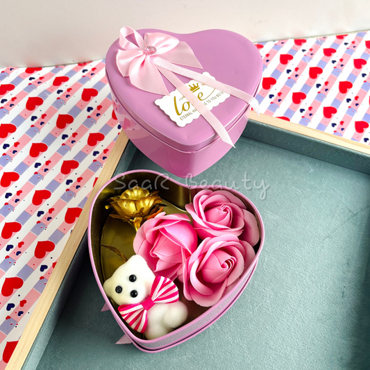 Heart-shaped Valentine’s Day gift box with artificial roses, a small teddy bear, a golden rose, and a decorative ribbon—perfect for romantic occasions.