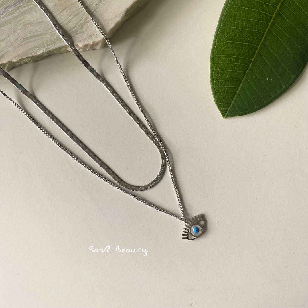 Metal chain necklace with a pendant in the shape of a EVIL EYE. Adjustable length with a trigger clasp.  Accessory Style:&amp;nbsp;Pendant necklace Description: ANTI TARNISH SILVER SNAKY EVIL EYE PENDANT NECKLACE NECKPIECE   Country of production:&amp;nbsp;India Common generic name:&amp;nbsp;Necklace Net Quantity:&amp;nbsp;1 N     Composition  Metal 80%, Polymethyl methacrylate 10%, Steel 10%