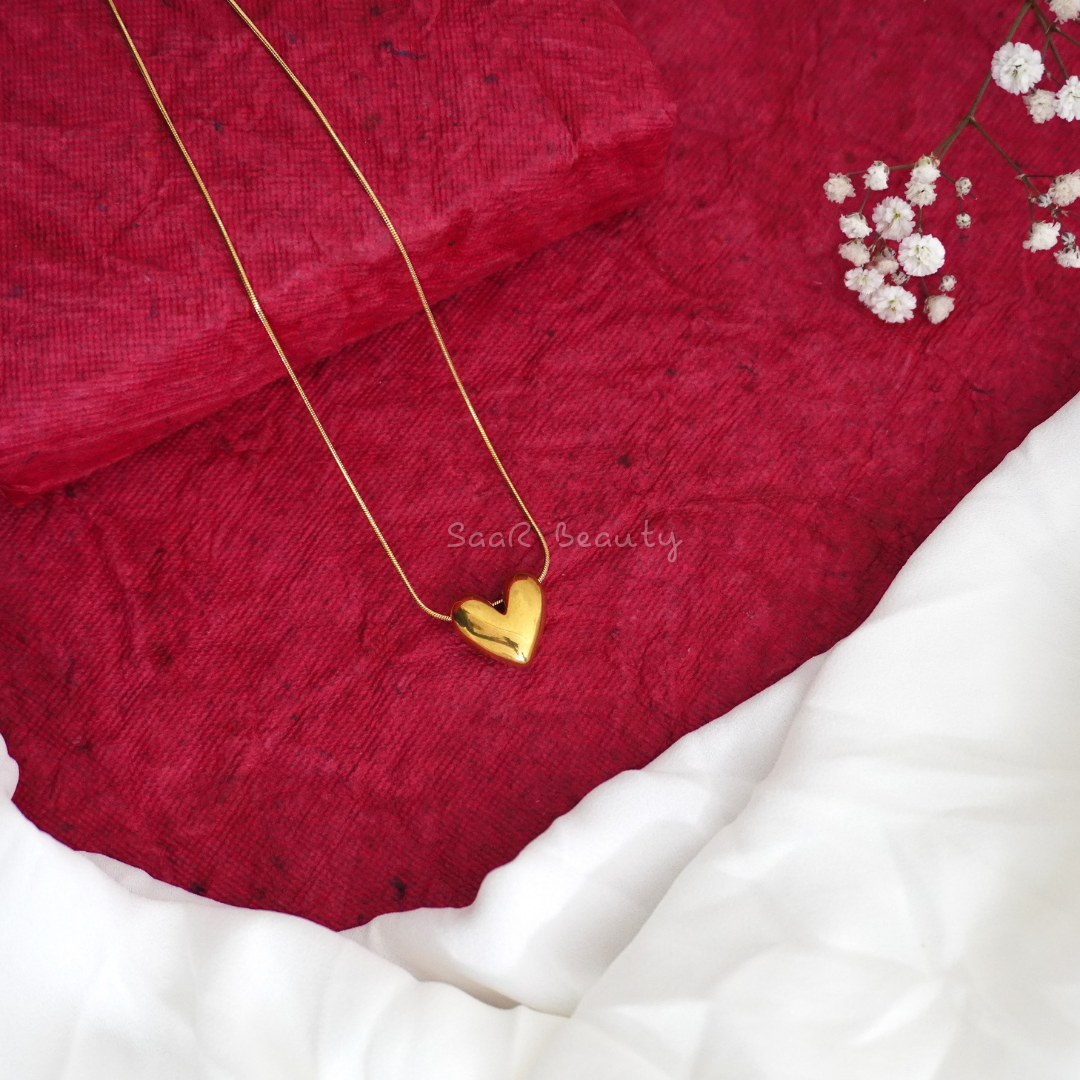 Gold heart pendant necklace by SaaR Beauty, featuring a sleek, minimalist design with anti-tarnish waterproof stainless steel and hypoallergenic properties.