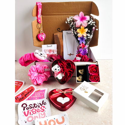 SaaR Beauty Valentine’s Gift Set – A luxury red-themed hamper featuring a necklace, earrings, floral hair clips, satin scrunchies, a keychain, stickers, and more.