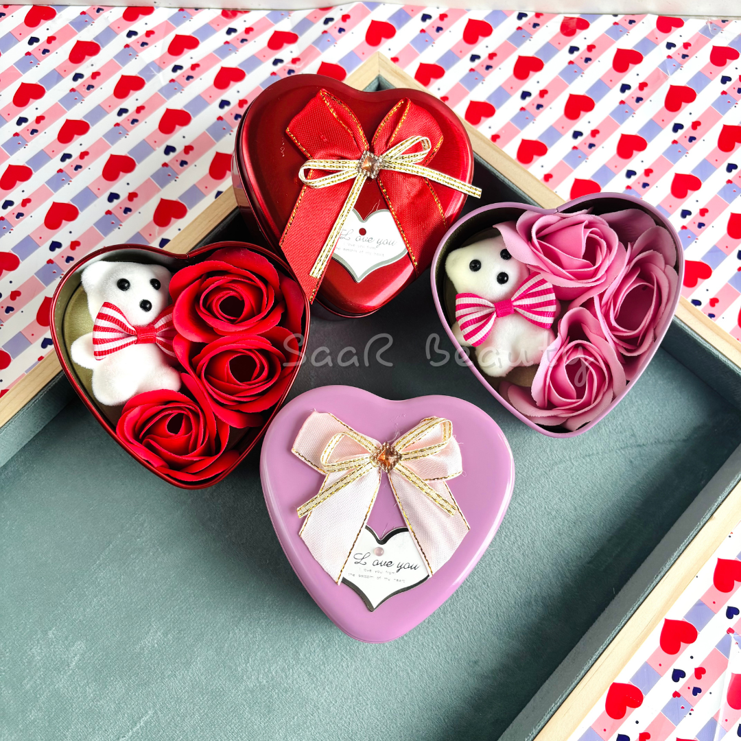 Medium-sized heart-shaped gift box with a plush teddy bear, artificial roses, a satin ribbon, and a love tag—ideal for romantic occasions and gifting.