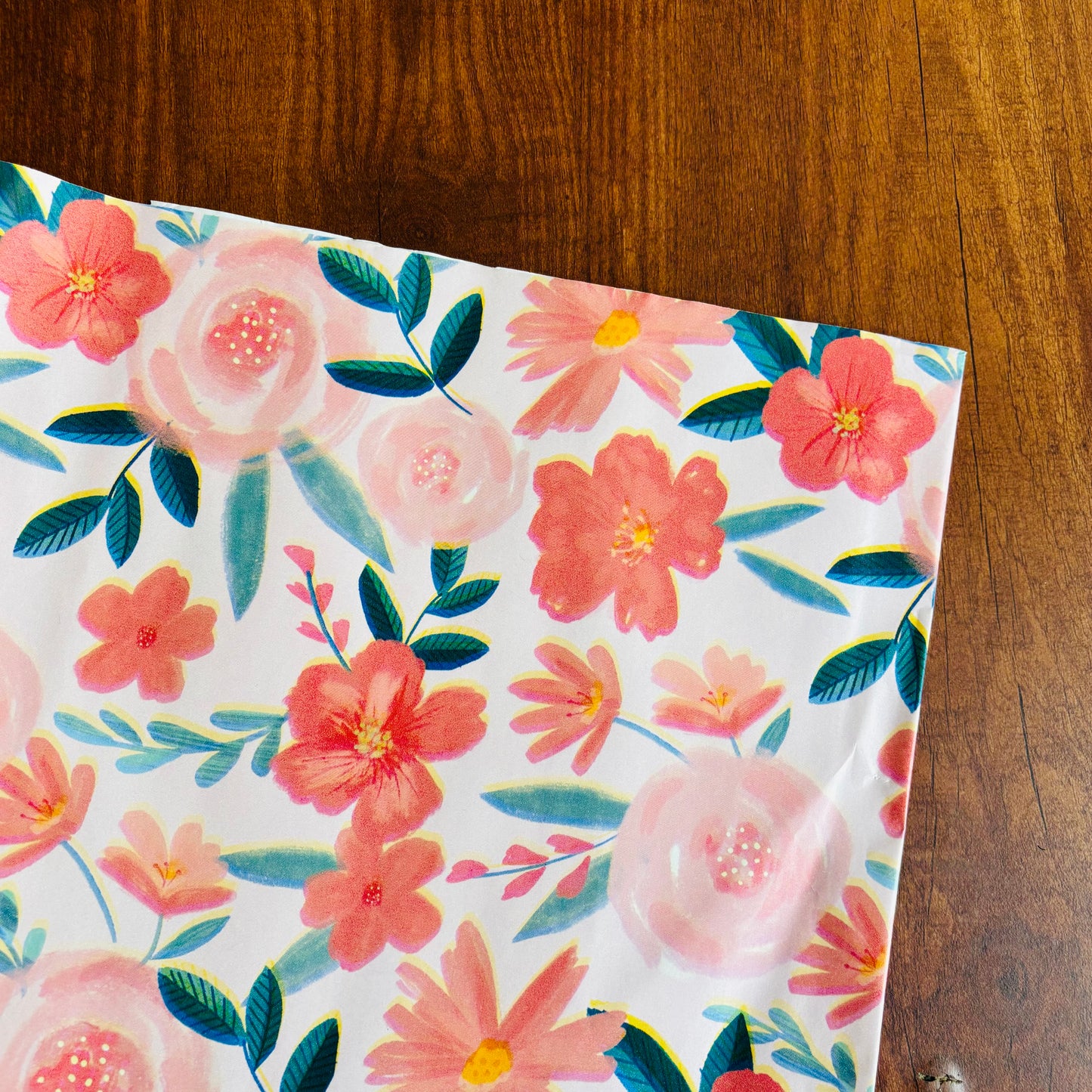 Floral-patterned paper on a wooden surface Romantic pink floral gift wrap with watercolor-style blooms and green leaves – perfect for weddings and spring gifts
