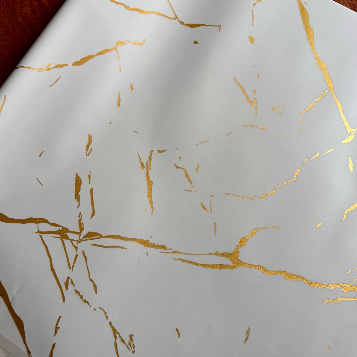 White paper with gold leaf patterns Elegant white marble gift wrap with shimmering gold foil veins – perfect for luxury gifting