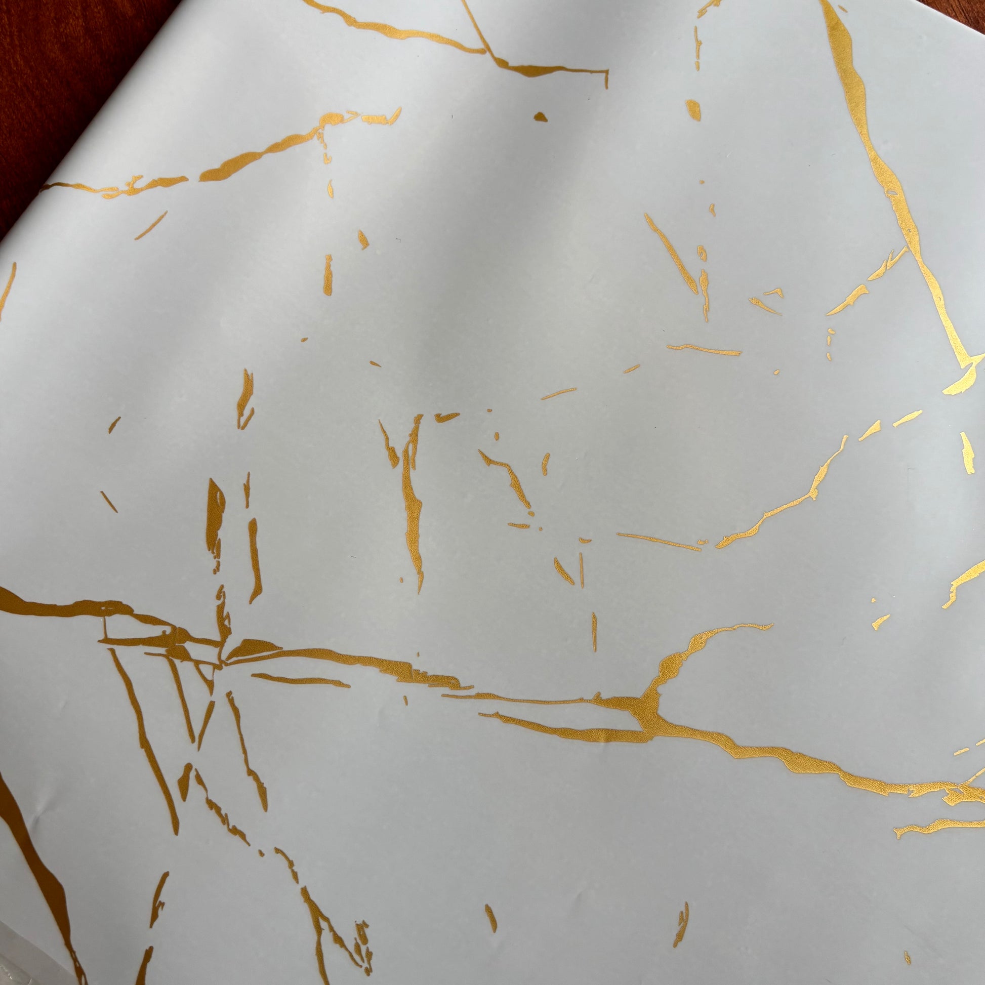 White paper with gold leaf patterns Elegant white marble gift wrap with shimmering gold foil veins – perfect for luxury gifting