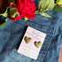 Gold heart-shaped earrings on a card with a red rose and denim Trendy quilted heart design stud earrings for women background