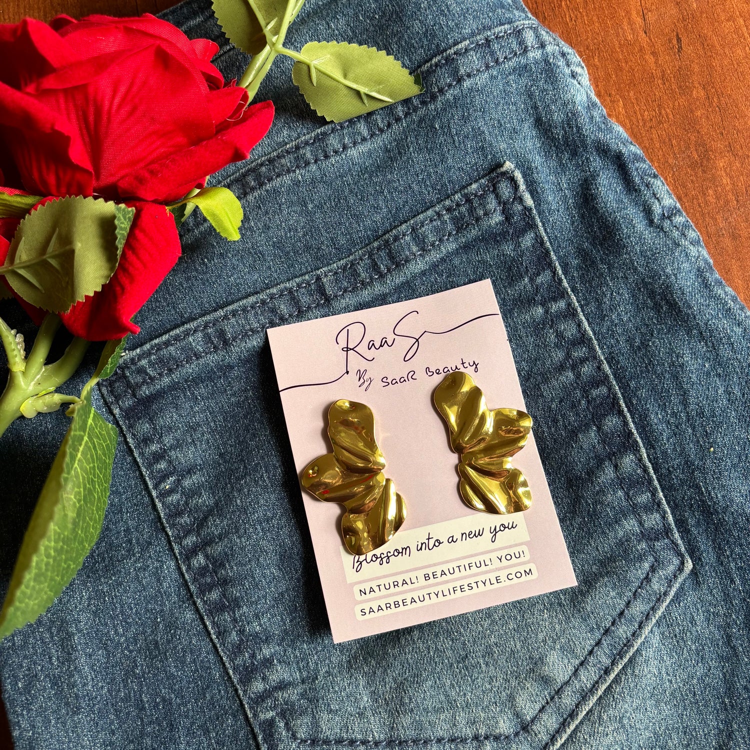 Gold butterfly earrings on a card with a red rose on denim fabric Trendy floral design gold finish earrings for women