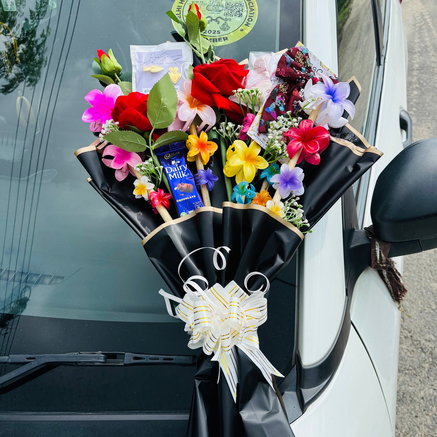Bouquet of flowers with a chocolate bar attached to a car door