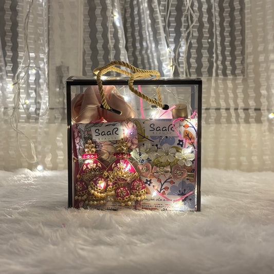 Two decorative items in a clear bag with 'SaaR' branding on a textured surface.interesty fairy light hamper gift box with earrings, scrunchie, and hair accessories – Saar Beauty