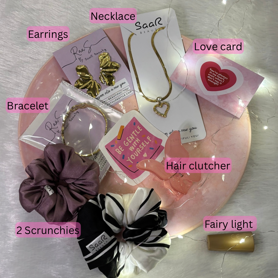 Collection of jewelry and accessories on a pink plate with labels Saar Beauty Buy 3 Get 5 Free Hamper – Includes waterproof jewelry, scrunchies, butterfly clip, fairy lights, and gifting card.