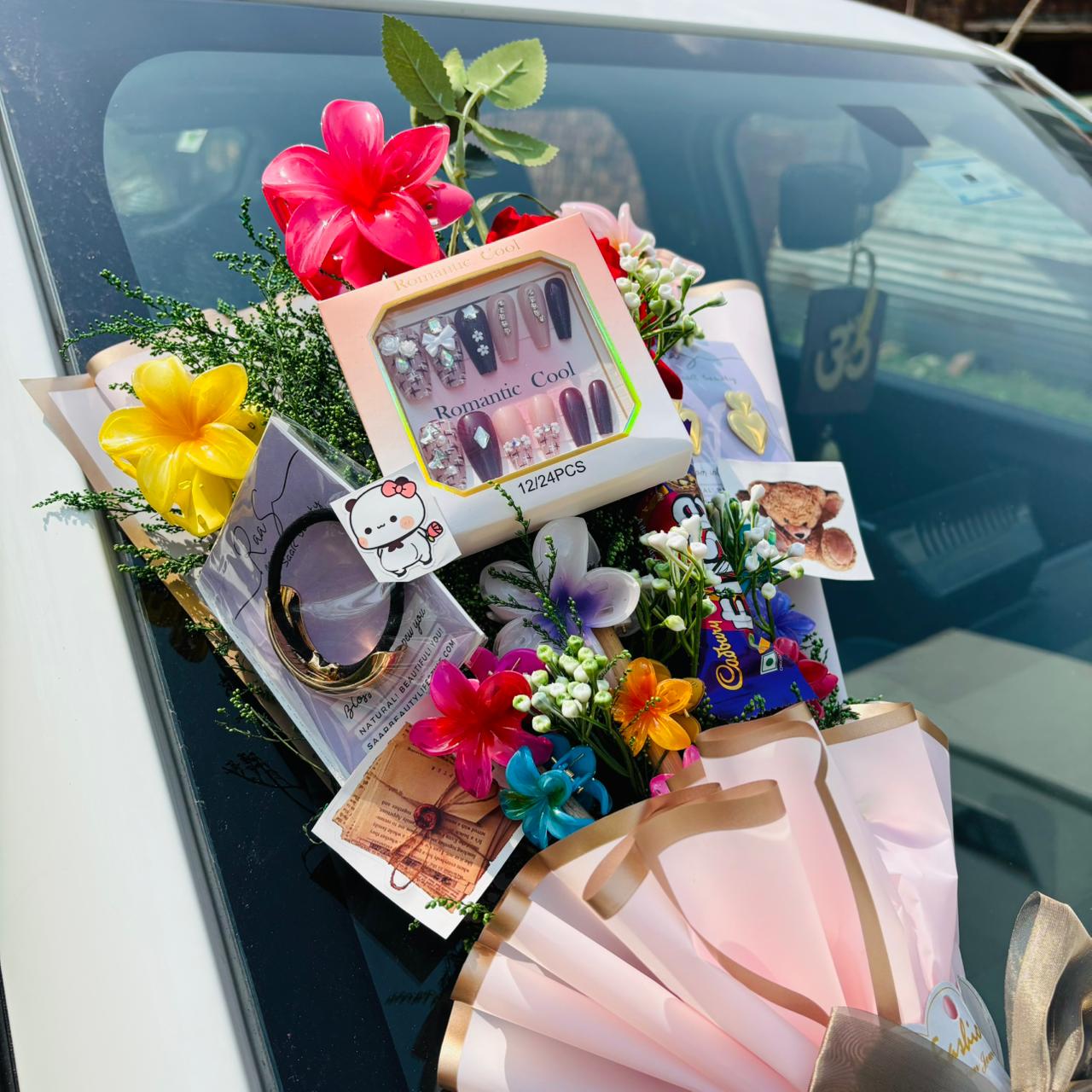 Gift basket with flowers and stationery items on a car window Pinterest-inspired Saar Beauty Forever Gift Bouquet with hair claws, nail box, and jewelry